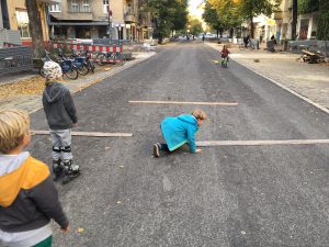 KInder legen auf der Straße Latten zur Verkehrsbreuhigung aus